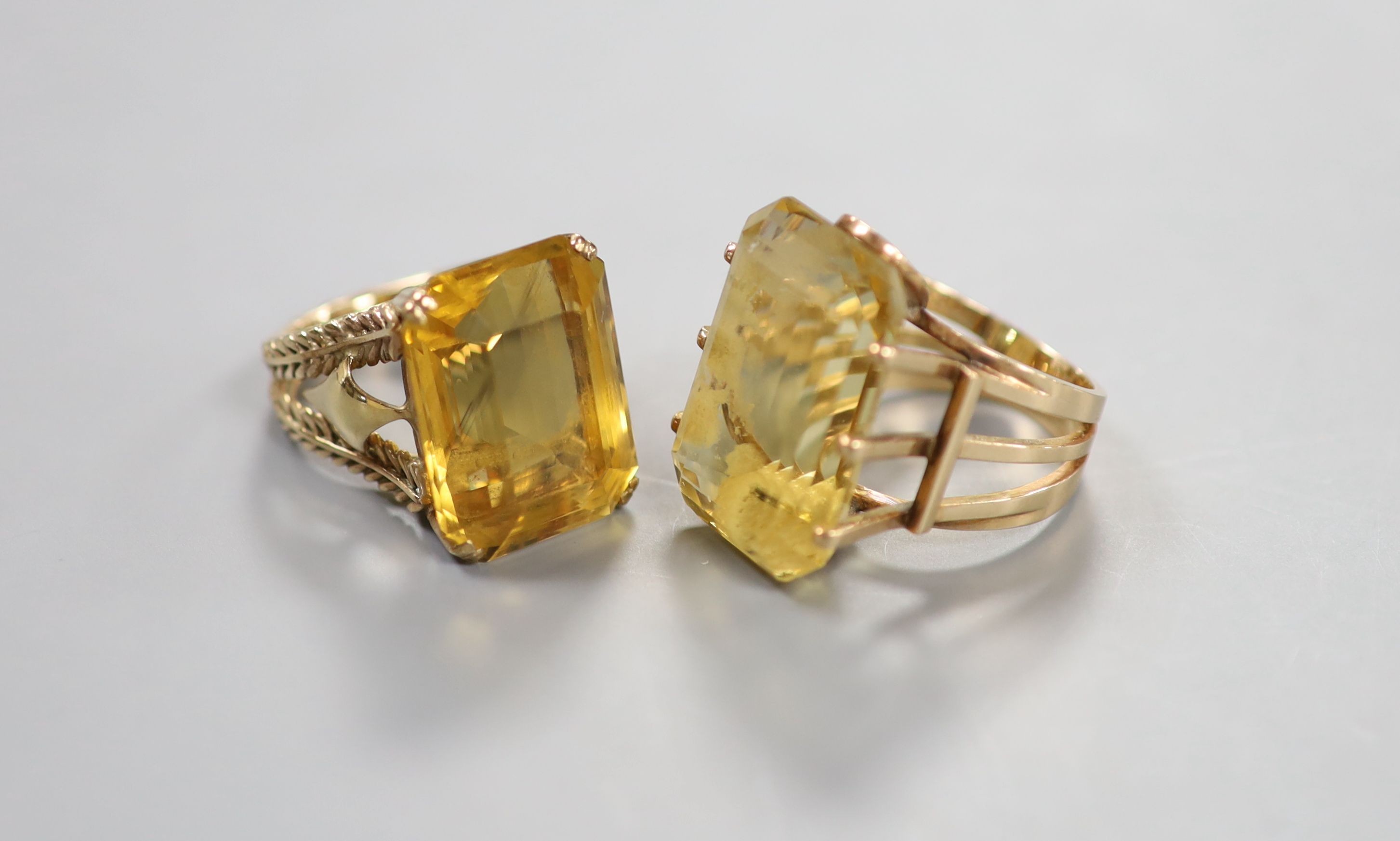 Two yellow metal and citrine set dress rings, one faintly marked 9ct, sizes L/M & P, gross weight 27 grams.